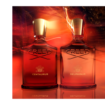 Two Creed perfume bottles, a red one with text CREED CENTAURUS and an orange one with text CREED DELPHINUS, are reflected on a surface against a swirling red and orange background.