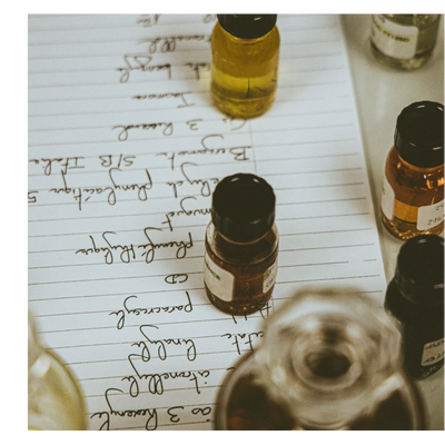 Small glass bottles containing liquids sit on a sheet of paper with handwritten notes including 3 Resorcin Citronellol Linalool Paracresol CD Phenylactique muguet Eucalyptus Phénylacétique 5 Bergamot 3 Ris Italia S/B Jakon th benzyle 24 NCE.