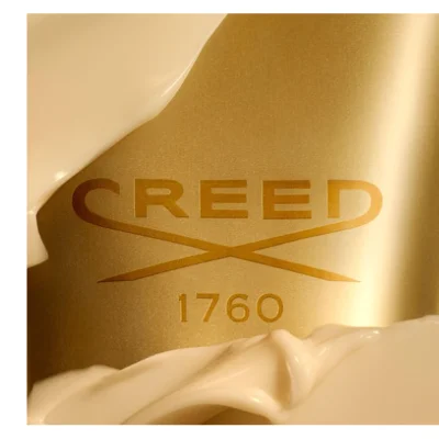 Creamy white product swirled around a golden surface with the text CREED, an interlocking X design, and 1760.